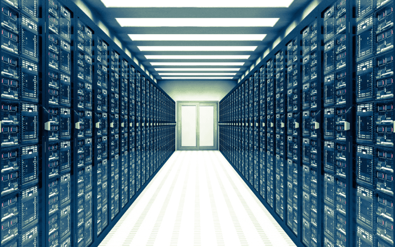 Wide hallway in a data center with endless rows of server racks on both sides, leading to a bright white light at the end. The scene conveys high-tech efficiency.