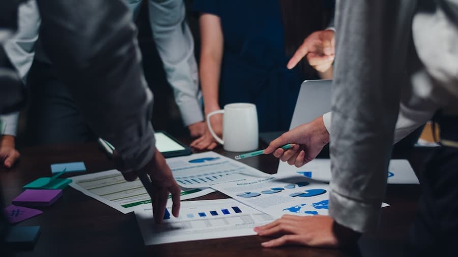 A group of people discussing data charts and strategy, indicating the execution phase of a business project.