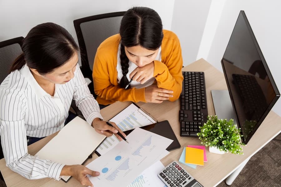 Two professionals reviewing documents at a desk, demonstrating our dedicated consulting services for financial sector hosting needs.