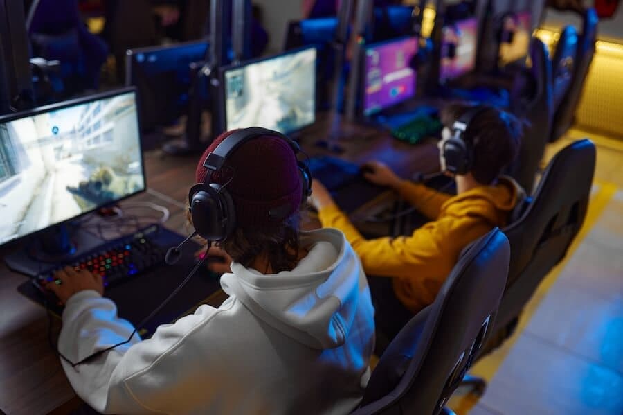 A group of gamers at a LAN party, each using high-performance computers, representing gaming server hosting for smooth gameplay.