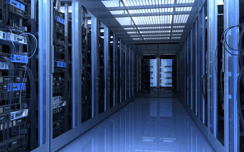 A sleek, futuristic server room with rows of blue-lit server racks on both sides. Cables and equipment fill the space, conveying high-tech efficiency.