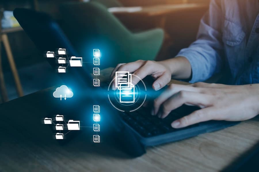 Person working at computer with floating digital storage icons, illustrating our immutable storage capabilities for data integrity.