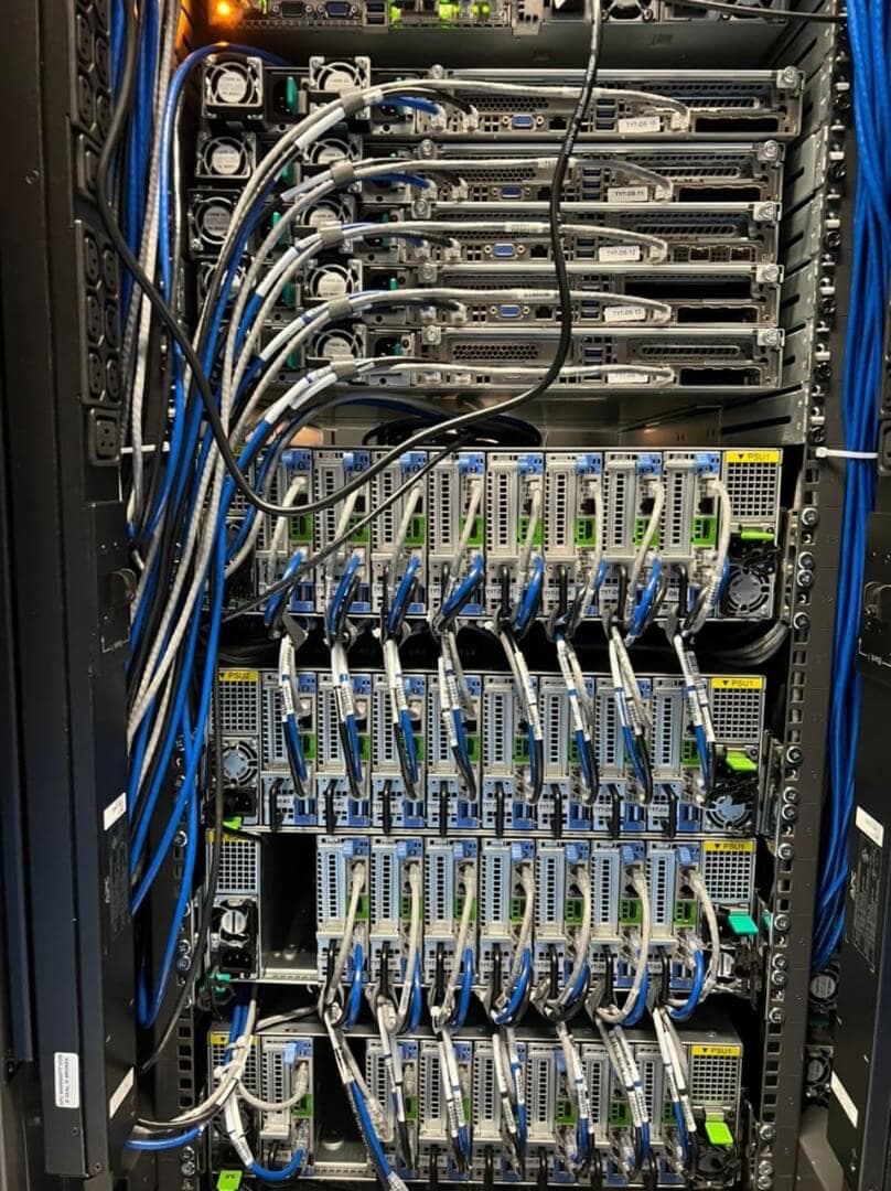 High-density server rack with precisely organized blue network cables connecting to blade servers with active status indicators