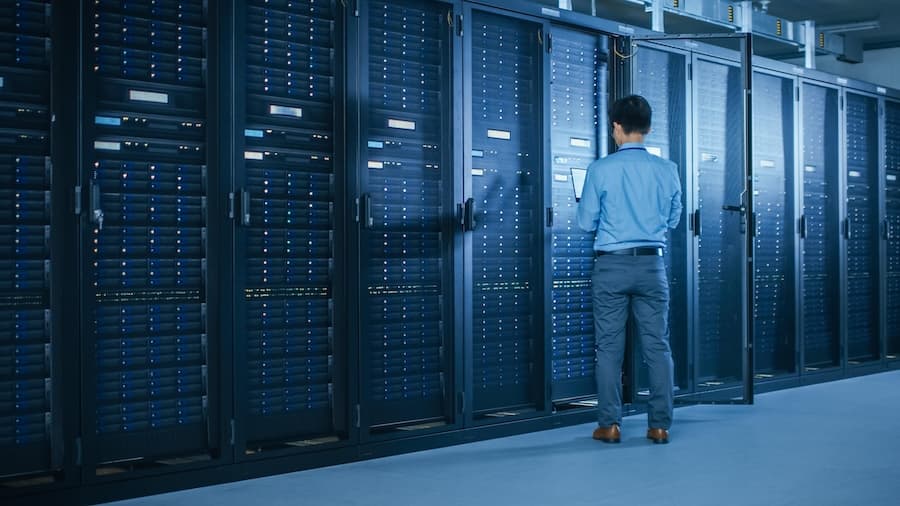 A technician inspecting server racks in a data center, symbolizing managed colocation services for secure server hosting.