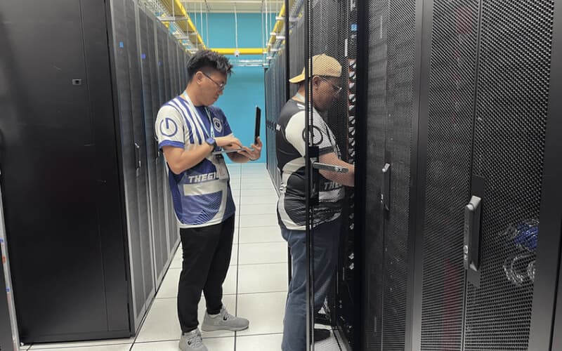 Two technicians discussing server configurations in a data center, highlighting dedicated server management services.
