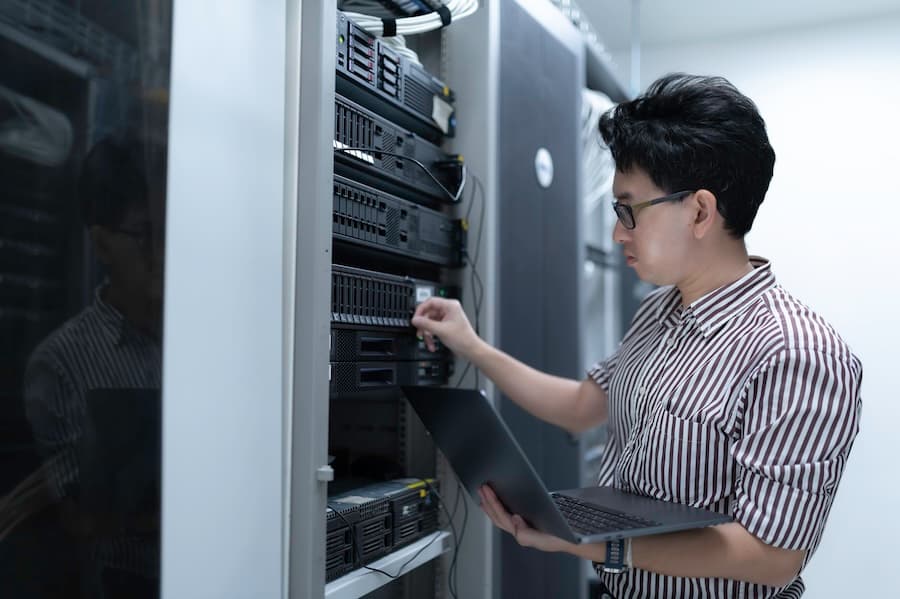 Two technicians discussing server configurations in a data center, highlighting dedicated server management services.