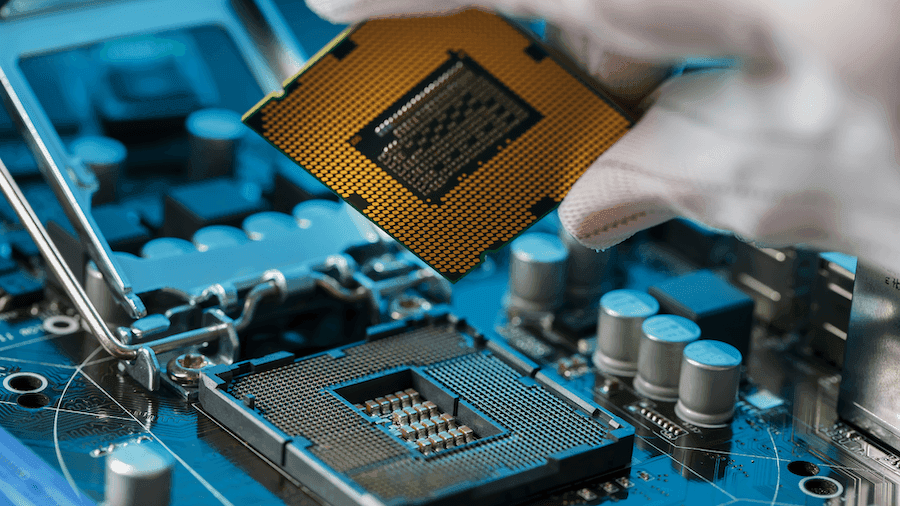 A gloved hand carefully places a gold-toned CPU into a motherboard socket. The focus is on the intricate connections, evoking precision and technology.
