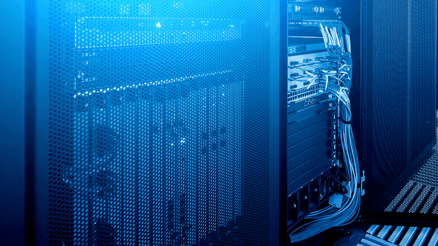 A blue-lit server room with open racks displaying network hardware and cables. The perforated casing and organized wiring suggest a high-tech environment.