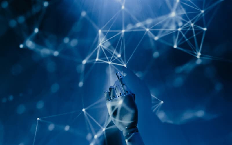 A hand touching a virtual network interface with interconnected nodes, representing self-hosted business tools and automation solutions.