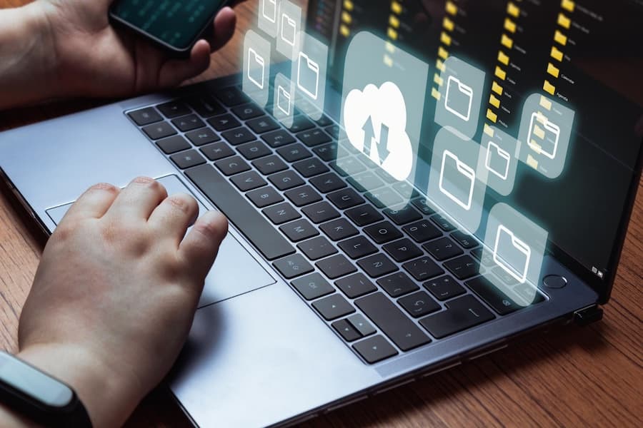 Hand accessing cloud backup interface on laptop keyboard, representing our user-friendly self-service backup platform.