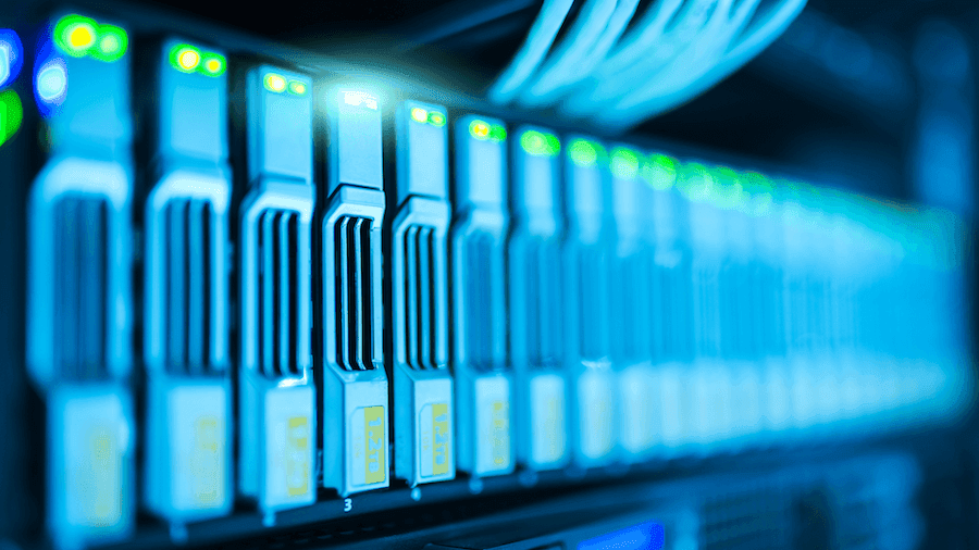 Close-up of illuminated blue server rack in a dimly lit data center. Rows of sleek, modern hardware emphasize advanced technology and connectivity.