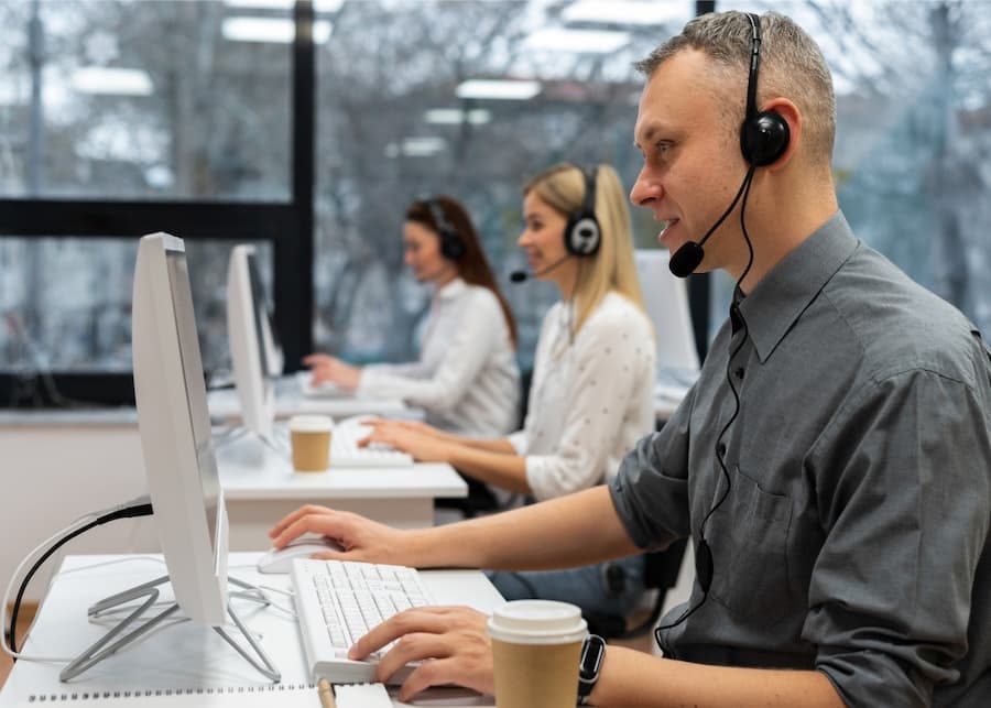 A customer support team wearing headsets and working on computers, representing ongoing technical support services.