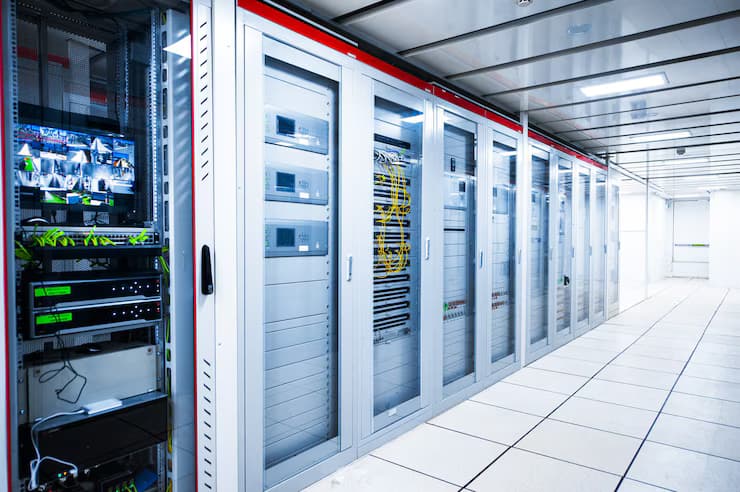 A row of sleek, white server racks in a brightly lit data center.